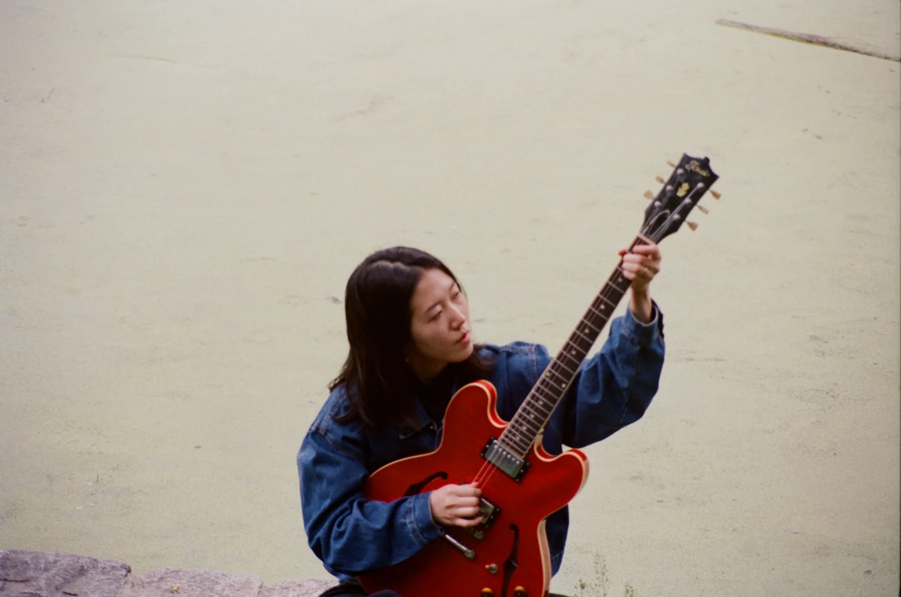 Guitarist Erika Toda playing a red electric guitar